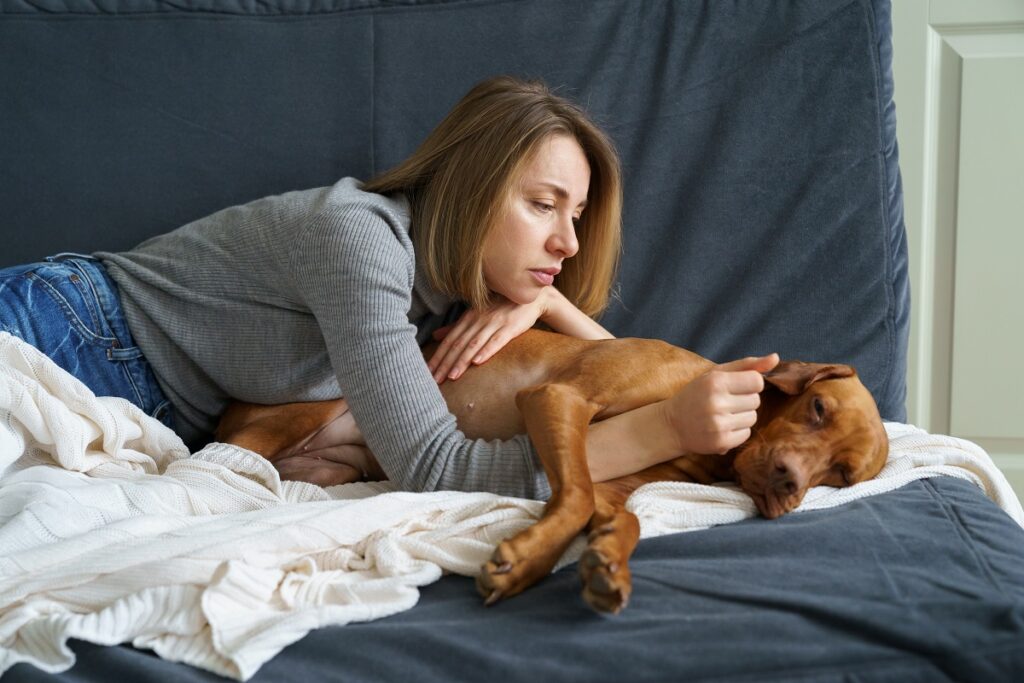 Worried Woman Taking Care Of Her Sick Dog