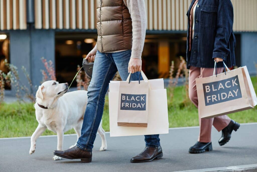 Adult Couple Holding Shopping Bags With Black Friday While Walking Outdoors